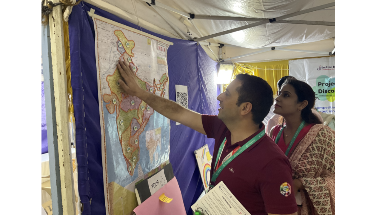 This picture is from a Project Discovery solution stall. One person with vision impairment is exploring the tactile map of India to know the states that Project Discovery has reached out. One project discovery team member is guiding him.